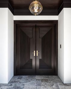 an entrance with two double doors and a chandelier