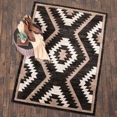 a black and white area rug with a pair of shoes on it next to a bag