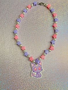 If you love pastel colors and cute jewelry, then this kawaii beaded necklace is the perfect addition to your aesthetic! Consisting of purple & pink stars with pearls, and a cute cat, this necklace can't be found anywhere else but here✨. Check out our beaded necklaces section to find more unique designs that are truly OOAK. *Stainless steel material only *Pendant is lightweight *Choose from 3 different lengths (prices vary) If you have any questions, please don't hesitate to ask! We are friendly:) Visit our official website: www.yeetincolorboutique.com and follow us on Instagram: @yeetincolorboutique Cute Pastel Beaded Jewelry, Kawaii White Beaded Jewelry, Kawaii Pastel Jewelry For Gifts, Cute Multicolor Charm Necklaces, Handmade White Kawaii Necklace, Playful Pink Charm Necklaces For Jewelry Makers, Pastel Kawaii Jewelry Perfect For Gifts, Pink Kawaii Jewelry With Colorful Beads, Pink Round Beads Kawaii Jewelry