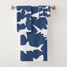 a blue towel with white sharks on it hanging from a metal bar in front of a wall