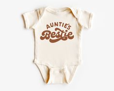 Auntie's bestie one piece romper, nephew niece gift bodysuit, pregnancy announcement one piece, baby reveal top, new infant short sleeve romper Packaging:  The item will be folded and individually package into resealable clear poly bags. It will then be placed inside a white polymail bag to be shipped to you. Material:  100 % cotton  Regular fit, midweight 180 gsm  preshrunk to minimise shrinkage Washing Instruction: Wash the T Shirt before wearing it. Cold, gentle wash setting with like colours only Flip the shirt inside out before washing Do not tumble dry Do not use harsh detergents or bleach Do not dry clean Warm iron, inside out This shirt is made in Australia. Please check our shop for more T shirts. Please leave us a review to help our shop grow. Aunties Bestie Onesie, Personalized Fitted Onesie For Birthday, Fitted Short Sleeve Onesie For Birthday, Trendy White Short Sleeve Bodysuit, Fitted Short Sleeve Bodysuit With Letter Print, Funny Customizable Fitted Onesie, Casual Fitted Short Sleeve Bodysuit With Letter Print, White Short Sleeve Trendy Bodysuit, Funny Short Sleeve Onesie For Birthdays