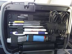 the inside of a car with pens, pencils and other office supplies in it