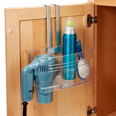 a cabinet door is open to show the bathroom accessories and hairdryer in it