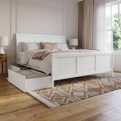 a white bed sitting in a bedroom on top of a hard wood floor next to a window