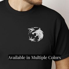 Show off your love for the Witcher with this Witcher Logo Tshirt featuring the iconic Wolf Head design, perfect as a gift for gamers and Witcher 3 fan merch. This unisex cotton tee is the ultimate nerdy gift and a standout video game tee for any gaming shirt collection. Details: -- 100% Cotton -- Tearaway neck label -- Multiple Colors and Sizes -- Unisex Crewneck How to Order: 1. Select Size 2. Select Color 3. Add To Cart 4. Select Shipping Method Shipping:  :: Production takes 1-2 Days :: Expre Black Logo Emblem T-shirt, Black Short Sleeve T-shirt With Logo Emblem, Black Tops With Logo Emblem For Streetwear, Graphic Tee With Logo Emblem And Short Sleeves, Short Sleeve T-shirt With Logo Emblem For Streetwear, Cotton Tops With Logo Emblem For Streetwear, Black Short Sleeve Tops With Logo Emblem, Black Short Sleeve Top With Logo Emblem, Graphic Tee With Logo Emblem