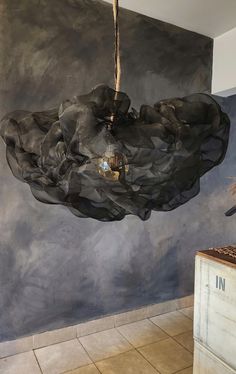 an artisticly designed chandelier hangs from the ceiling in front of a painting