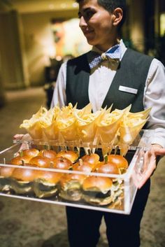 a man holding a tray full of food