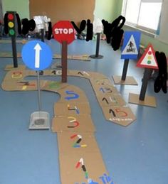 children's play area with various road signs and traffic lights on the floor in front of them