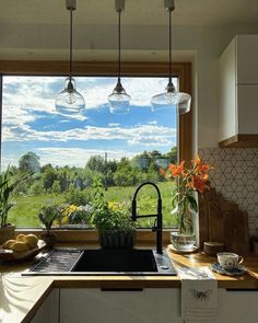 a kitchen with a sink, stove top oven and lots of lights hanging from the ceiling