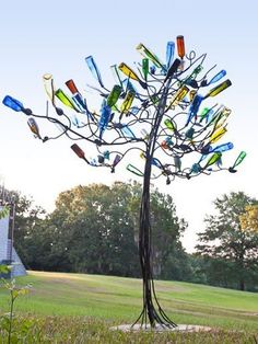 a tree made out of glass bottles in a field