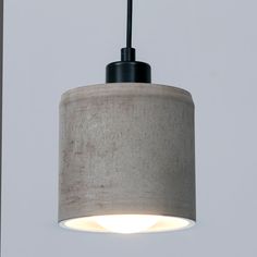 a light that is hanging from the ceiling in a room with gray walls and flooring