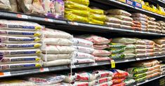 an aisle in a grocery store filled with lots of bags of rice and other items