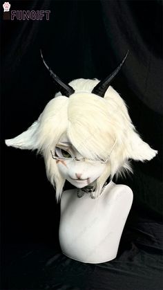 a white wig with horns on top of a mannequin's head in front of a black background