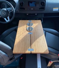 the interior of a vehicle with a wooden table and steering wheel