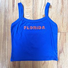 Florida blue and orange tank with star lettering. Perfect for a tailgate or showing spirit! Orange Tops For Women, Sporty Summer Tank Top For College, Sporty Tank Top For College In Summer, Sleeveless Tops For College Summer, Casual Summer Tank Top For College, Sleeveless Summer Tops For College, Casual Sleeveless Tank Top For College, Cotton Tank Top For College In Summer, Sleeveless College Tops With Team Name