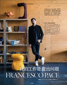 a man standing in front of a shelf filled with vases and other items on it