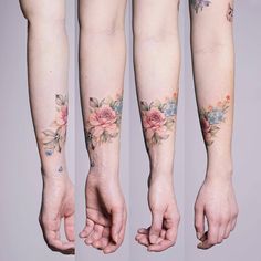 three women with tattoos on their arms holding hands