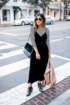 Azani’s tip to make the dress brunch-ready is to layer a 3/4-sleeve tee underneath it. Then add a pair of statement boots and accessorize with a classic bag. The cherry on top? An... Boots With A Dress, How To Wear Ankle Boots, Velvet Slip Dress, Striped Shirts, Winter Dress Outfits, Mode Inspo