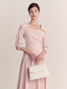 The Diamant Dress is a beautifully structured piece that exudes elegance and sophistication. This mid-length dress comes in a soft blush pink hue and features a unique, asymmetrical collar that adds a modern twist to the classic silhouette. The tailored bodice and A-line skirt provide a flattering fit, while the long sleeves with subtle cuff details enhance the dress's formal appeal. - The Diamant Dress is characterized by its distinct asymmetrical collar, offering a contemporary edge to a traditional design.- Crafted from a smooth, high-quality fabric, the dress drapes elegantly and maintains its shape throughout wear.- Its cinched waist and flowing A-line skirt accentuate the natural waistline and create a graceful, feminine profile.- Suitable for formal events and sophisticated gat Elegant Asymmetrical A-line Wedding Dress, Elegant Asymmetrical A-line Formal Dress, Elegant Asymmetrical Mini Dress, Feminine Wedding Dress With Asymmetrical Neckline, Chic Beige Midi Dress With Asymmetrical Neckline, Pink Dress With Asymmetrical Neckline For Formal Occasion, Elegant Asymmetrical Pink Dress, Beige Asymmetrical Neckline Cocktail Dress, Elegant Asymmetrical Wedding Dress For Spring