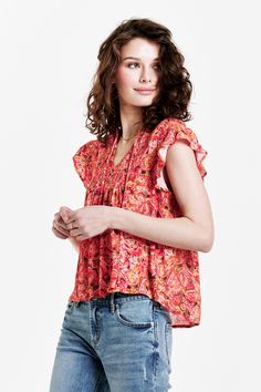 image of a female model wearing a VAYDA SMOCKED YOKE SHIRT AUTUMN PAISLEY DEAR JOHN DENIM Casual V-neck Top With Smocked Back, Bohemian V-neck Top With Smocked Back, Bohemian V-neck Tops With Smocked Back, V-neck Smocked Top With Smocked Bodice For Vacation, Summer V-neck Top With Smocked Bodice, Summer Rayon V-neck Tops, Flowy Smock Blouse, Casual Smocked Top With Flutter Sleeves, Feminine Top With Smocked Back And Flutter Sleeves