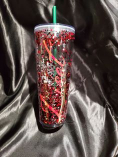 a tumbler cup with red and pink confetti on it