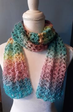 a white mannequin wearing a multicolored scarf