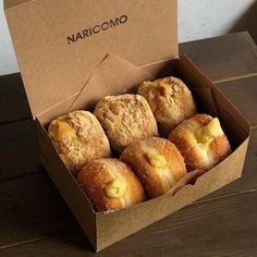 a box filled with pastries sitting on top of a wooden table