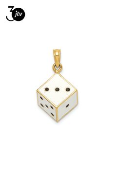 a white and gold pendant with two black dots on the front, one in the shape of a dice