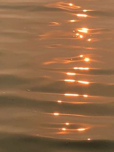 the sun is shining down on the water with ripples in it's wake