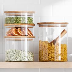 three clear containers filled with food on top of a wooden shelf