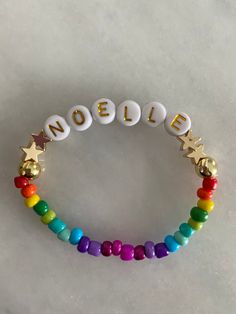 Beaded kids bracelets with rainbow and gold beads with gold lettering. Personalization available Bracelet Rainbow, Friendship Bracelets With Beads, Word Bracelet, Custom Bracelet, Kids Bracelets, Rainbow Bracelet, Personalized Letters, Rainbow Beads, Star Bracelet