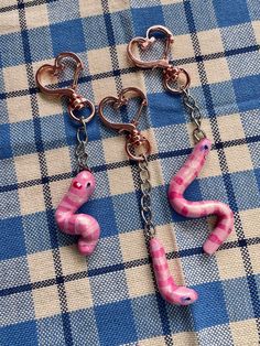 two pink and silver items on a blue checkered cloth with hearts hanging from them