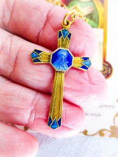 French antique Saint Therese cross necklace,  designed in the style of Art Deco with lines filled with blue enamel...in the center of the cross Saint Theresa holds a bouquet of roses with a cross embedded in the roses (she is always posed this way).  Cross measures approx 1.5" tall. The chain is 23" and has a crab claw connector. The chain is 14 karat gold filled, so it will not tarnish. Saint Therese of Lisieux is one of  the patron saints of France. She is also the patron of all children and t Saint Therese, Crab Claw, Enamel Art, St Therese Of Lisieux, Thérèse Of Lisieux, St Therese, Saints Medals, Art Deco Stil, French Antique