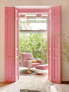 an open pink door leading into a living room