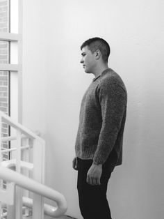 a man standing in front of a window next to a stair case