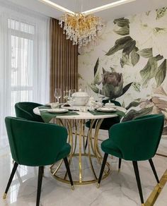 a dining room table with green chairs and a gold chandelier hanging from the ceiling