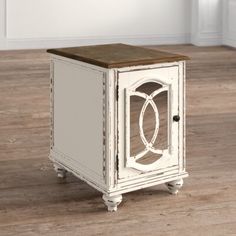 a small white cabinet with an open door on the front and side, sitting on a wooden floor