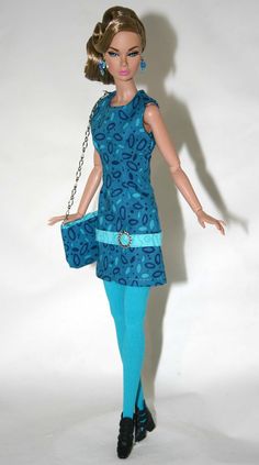 a barbie doll wearing a blue dress and holding a purse