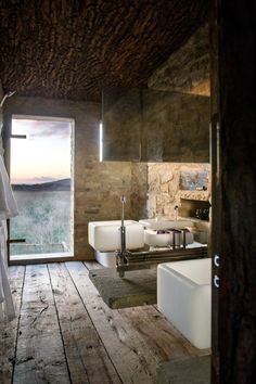 a bathroom with wooden floors and stone walls