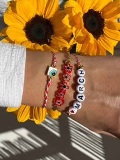 Three Bracelets for March with different central charms that will protect you from the spring's sun. The first bracelet has a tiny evil eye in rectangular shape, the middle bracelet a raw of tiny flowers and the last one is a bracelet with tiny letters that write ''LOVE MARCH'' and completes this unique set. You can wear them together or separetely as well. Find them only at Christina Christi Store. 👉 My Mens Bracelets Collection: https://etsy.me/2UunKla 👉 Express Shipping: https://etsy.me/3ik Red Bohemian Bracelets With Letter Beads, Bohemian Red Bracelets With Letter Beads, White Beaded Friendship Bracelets With Charms, Adjustable Red Bracelet With Letter Beads, Adjustable Beaded Bracelets For Good Luck, White Round Beaded Bracelet For Good Luck, Handmade White Good Luck Bracelets, Adjustable White Bracelet For Good Luck, Red Beaded Charm Bracelet For Friendship