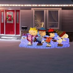 a christmas scene with peanuts and charlie brown sitting on a blanket in front of a house