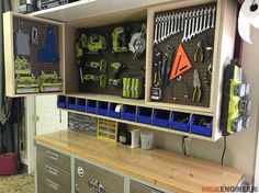 an organized workbench in a garage with tools on the wall and cabinets below