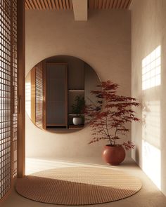 a round mirror sitting on the side of a wall next to a potted plant