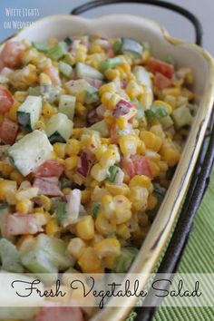 fresh vegetable salad in a serving dish on a green cloth with the words, fresh vegetable salad