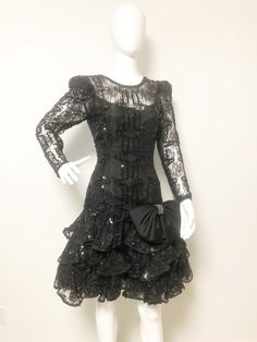 This is a black party dress from After Five. The dress has lace puff sleeves, a low cut v back neckline, lace overlay, sequins and tulle. If that wasn't enough, it also has a big satin 80's bow at the drop waist that is embellished with rhinestones. All the 80's bells and whistles are included with this one. Size tag 6. Check measurements carefully, no stretch. No flaws noted. Measurements taken with dress laying flat and doubled where appropriate. We recommend comparing measurements with an ite Embellished Black Dress, Dress Low Back, Low Back Dress, Black Party Dress, Low Back Dresses, Puff Dress, Beaded Jacket, Black Party Dresses, Blazer Designs