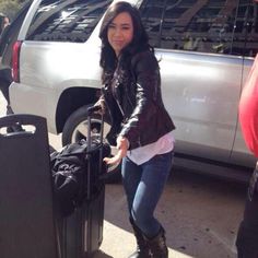 a woman is standing next to her luggage