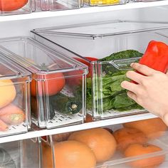 a person holding a red pepper in front of a refrigerator filled with fruits and vegetables