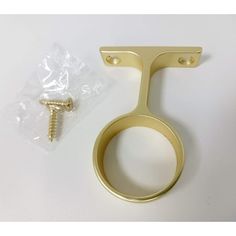 a pair of brass plated hooks with screws on the end and a plastic bag next to it