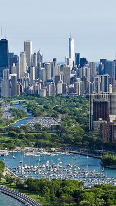 an aerial view of a large city with boats in the water and lots of tall buildings