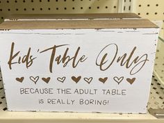 a sign that says kids table only because the adult table is really boring on it